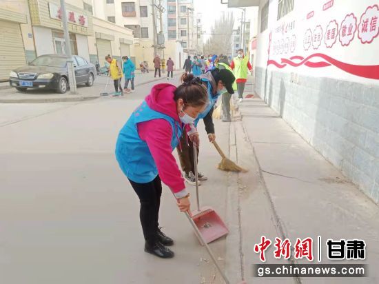 图为志愿者清扫卫生区域。